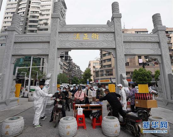  4月16日，進(jìn)出武漢漢正街步行街的人員在掃描健康碼。新華社記者 王毓國(guó) 攝